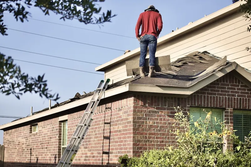 Professional roofer working on a residential roof in Layfield